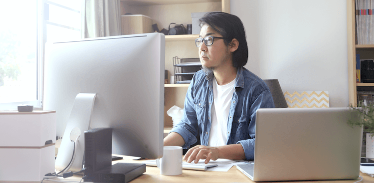 person sitting in a home office and working on a computer