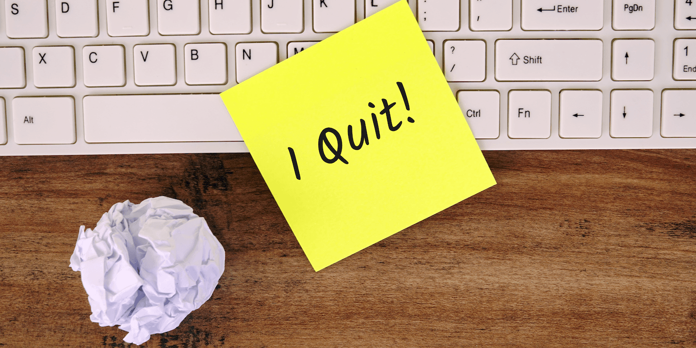 yellow sticky note that says, "I quit!" on a keyboard with a crumpled paper next to it